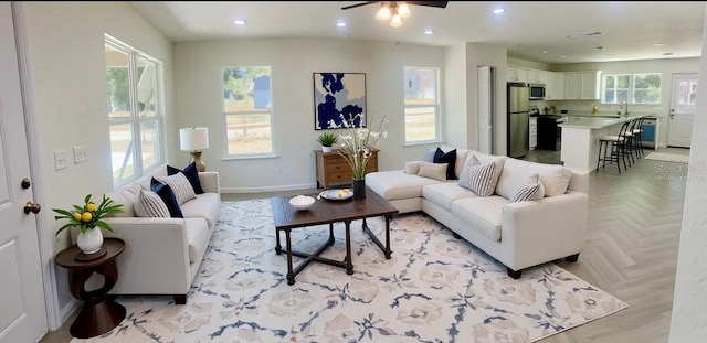 living area with ceiling fan, recessed lighting, visible vents, and baseboards