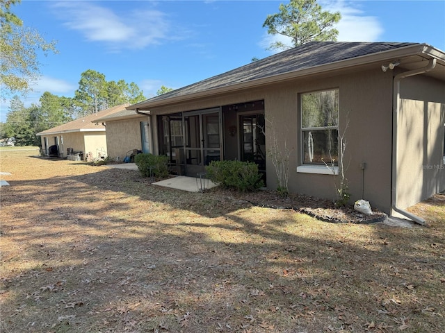 rear view of property featuring a sunroom