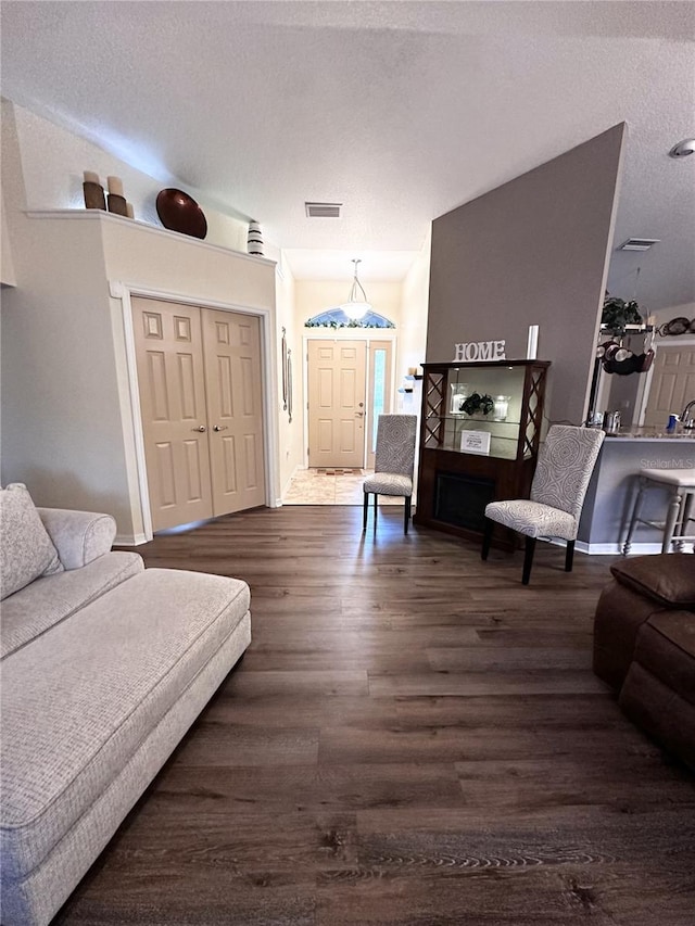 living room with dark wood-type flooring and a textured ceiling