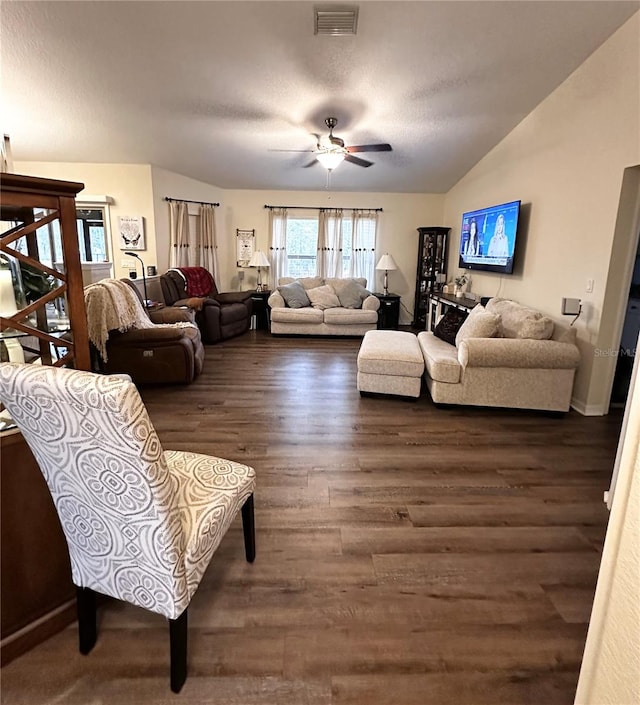 living room with ceiling fan, vaulted ceiling, and dark wood-type flooring