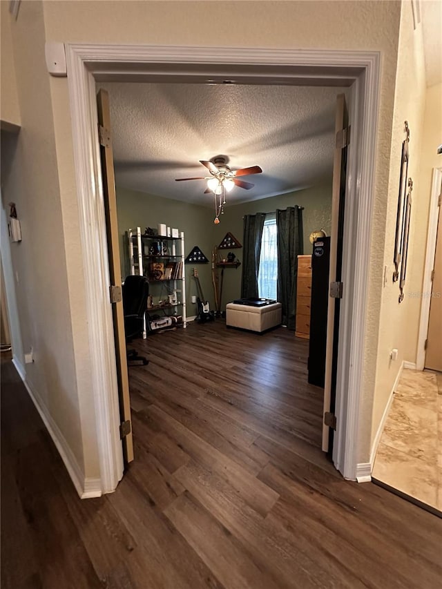 corridor featuring a textured ceiling and dark hardwood / wood-style floors