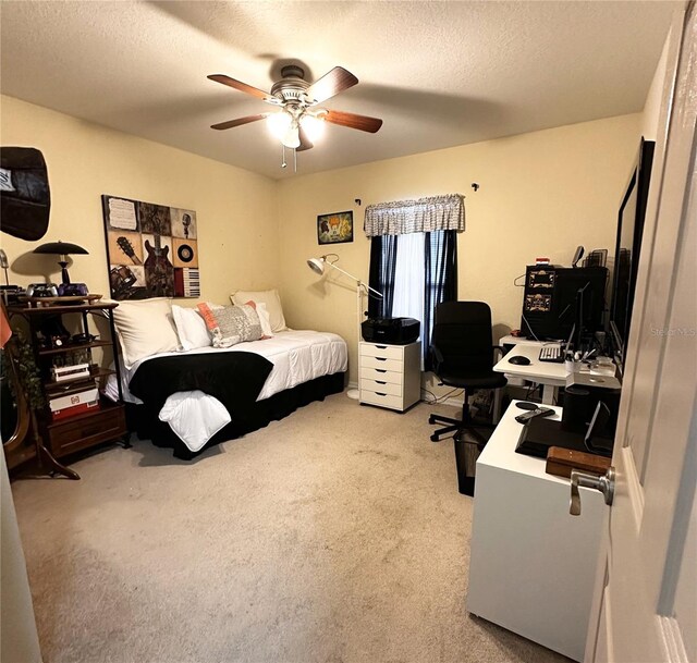 bedroom with ceiling fan, light colored carpet, and a textured ceiling