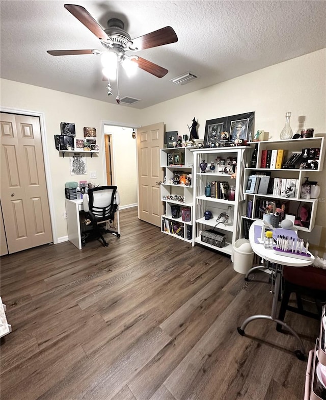 home office with ceiling fan, a textured ceiling, and dark hardwood / wood-style floors