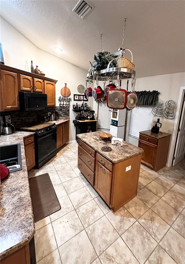 kitchen featuring black appliances, light stone countertops, a textured ceiling, backsplash, and light tile patterned flooring