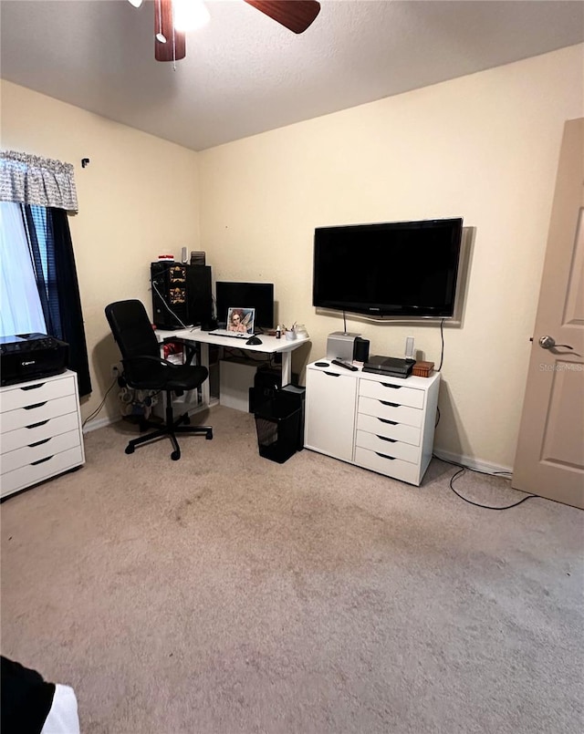 carpeted office space with ceiling fan