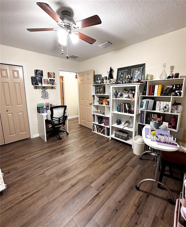 home office featuring a textured ceiling, ceiling fan, and dark hardwood / wood-style flooring