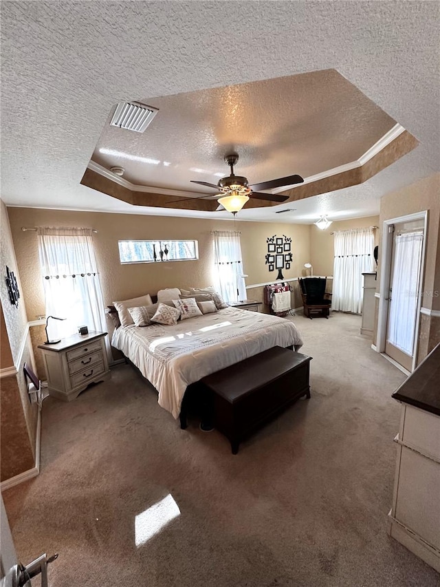 carpeted bedroom featuring ceiling fan, a textured ceiling, a tray ceiling, and crown molding