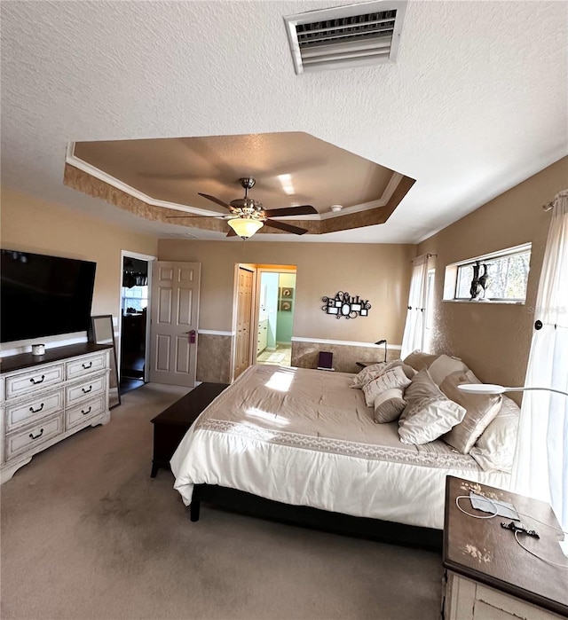 carpeted bedroom with ceiling fan, a textured ceiling, and a raised ceiling