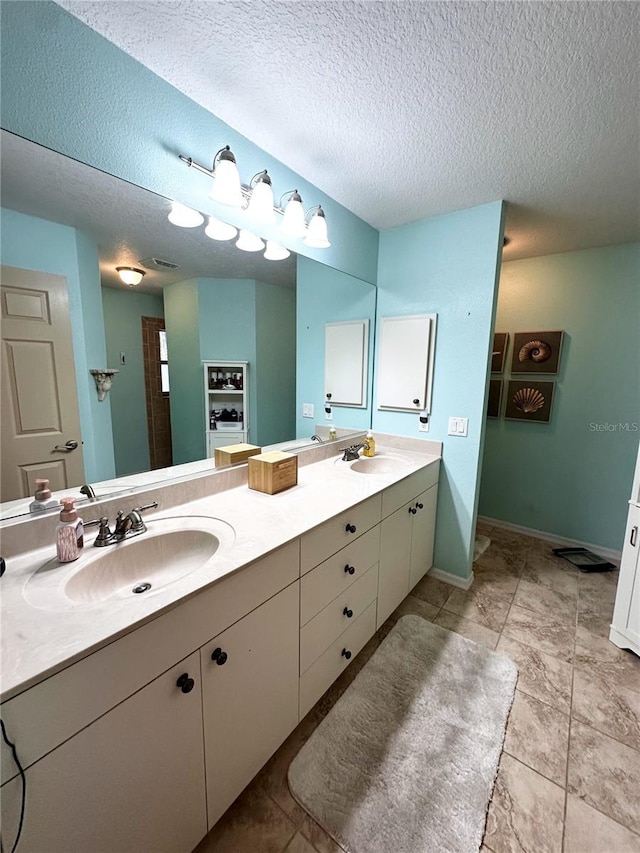 bathroom with a textured ceiling and vanity