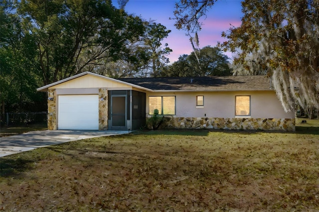 ranch-style house featuring a yard and a garage