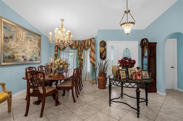 dining space featuring lofted ceiling, light tile patterned floors, and an inviting chandelier