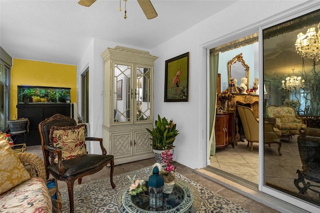 sitting room featuring ceiling fan with notable chandelier and light tile patterned flooring