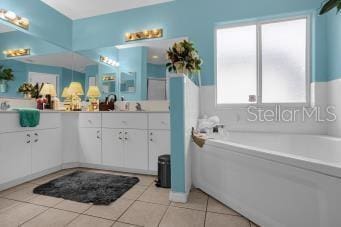 bathroom featuring tile patterned flooring, vanity, and a bathtub