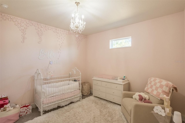 bedroom with a crib and a chandelier