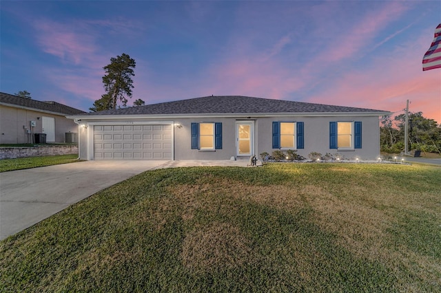 ranch-style house with a yard and a garage