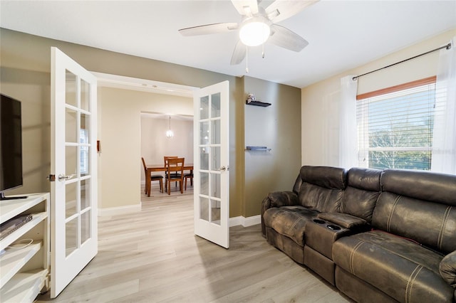 living room featuring ceiling fan, light hardwood / wood-style flooring, and french doors