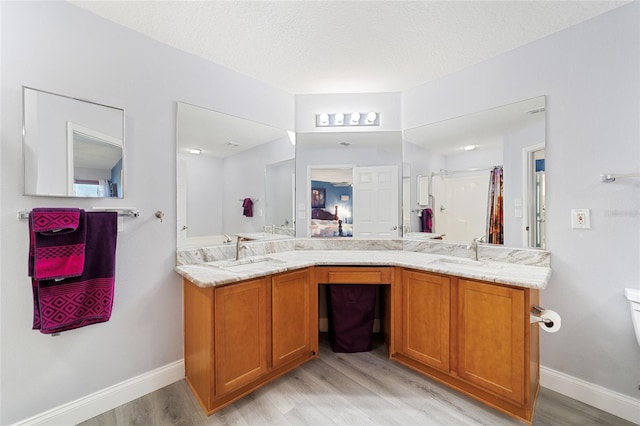 bathroom featuring a textured ceiling, hardwood / wood-style floors, an enclosed shower, and vanity