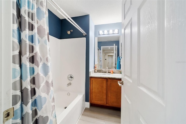 bathroom featuring hardwood / wood-style flooring, shower / bathtub combination with curtain, and vanity