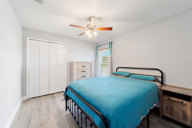 bedroom with a closet, ceiling fan, a textured ceiling, and light hardwood / wood-style flooring