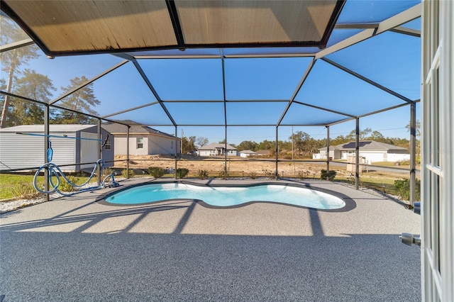 view of pool featuring a lanai, a storage unit, and a patio area