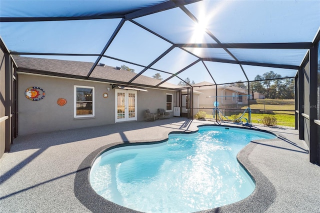 view of swimming pool with french doors, a lanai, and a patio area