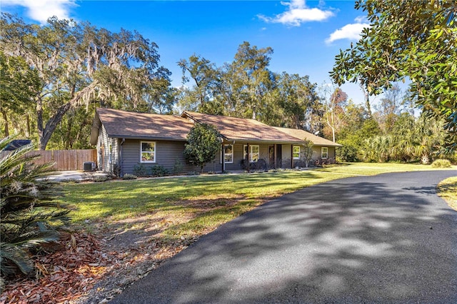 ranch-style house featuring central AC unit and a front lawn