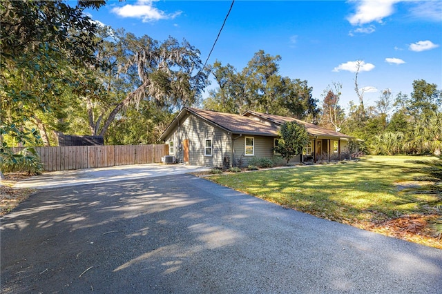 view of front of property featuring cooling unit and a front lawn