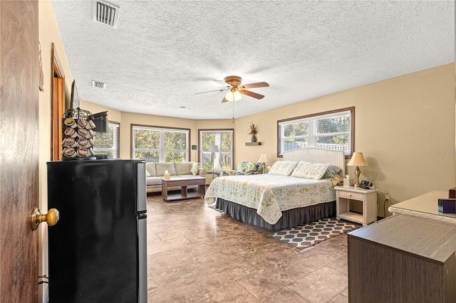 bedroom featuring stainless steel refrigerator and ceiling fan