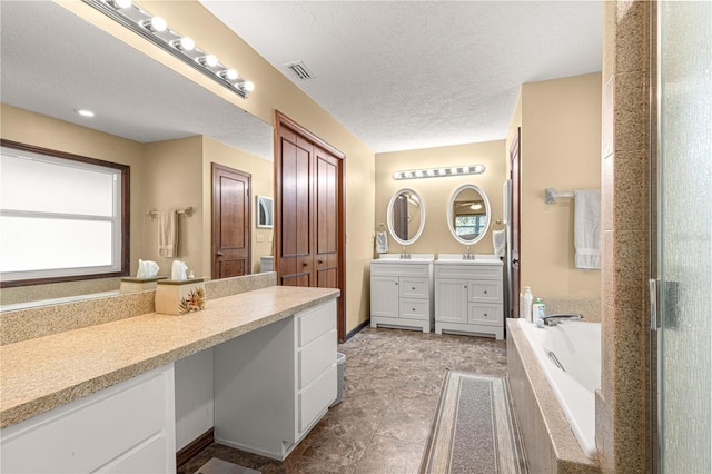 bathroom featuring a textured ceiling, vanity, separate shower and tub, and plenty of natural light