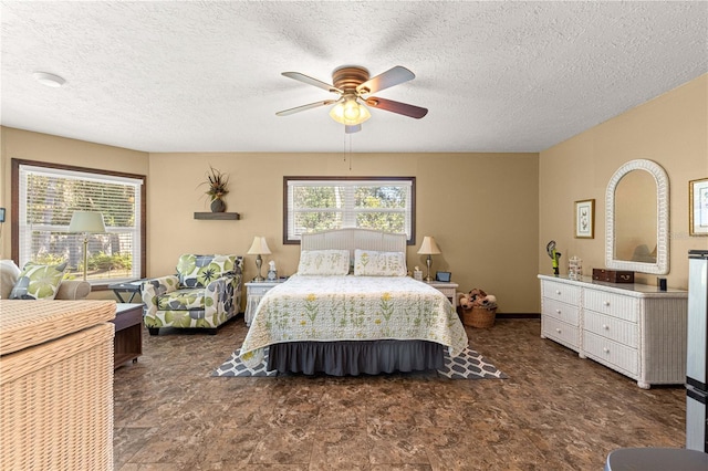 bedroom with ceiling fan and a textured ceiling