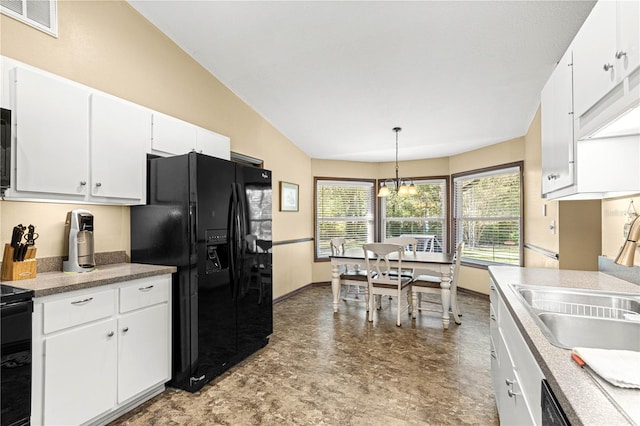 kitchen featuring black appliances, a notable chandelier, sink, white cabinetry, and decorative light fixtures