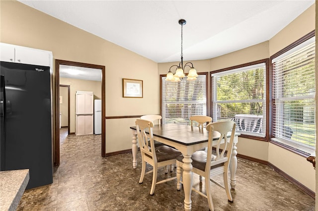 dining area featuring lofted ceiling and a chandelier