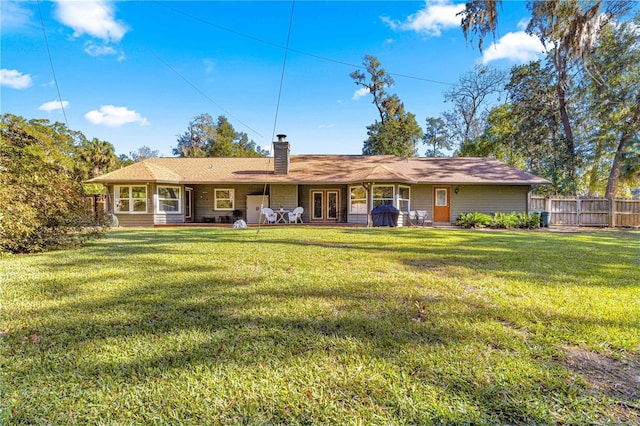 rear view of property with a lawn