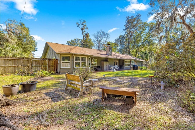 rear view of property featuring a lawn