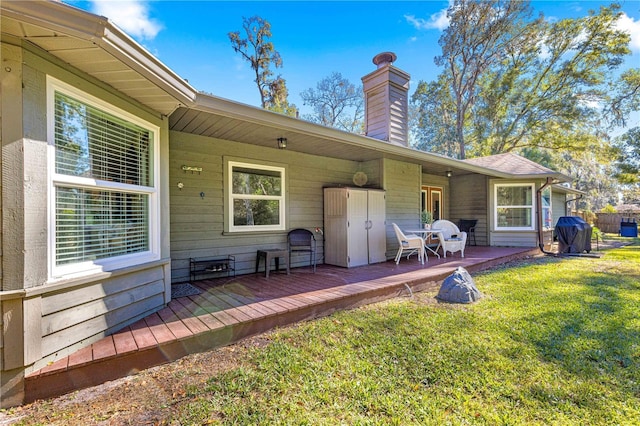 back of property featuring a yard and a wooden deck