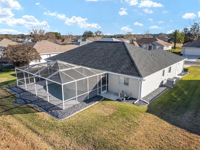 rear view of house with a lawn, a patio area, a lanai, and cooling unit