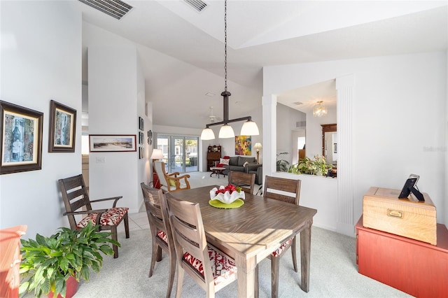 carpeted dining space with lofted ceiling and an inviting chandelier