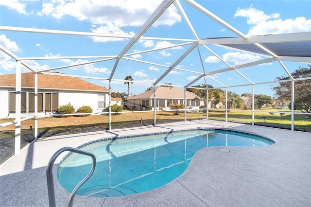 view of pool featuring a lawn, glass enclosure, and a patio