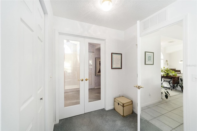 entryway featuring tile patterned floors, a textured ceiling, and french doors