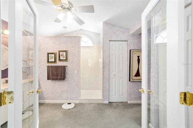 bathroom with french doors, a textured ceiling, ceiling fan, lofted ceiling, and a shower with shower door