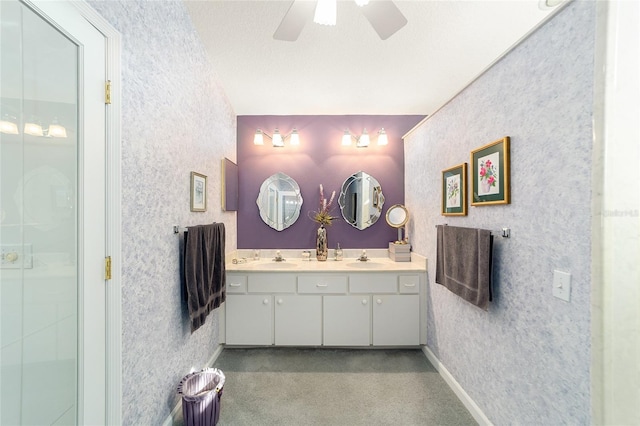 bathroom with ceiling fan, a textured ceiling, vanity, and walk in shower