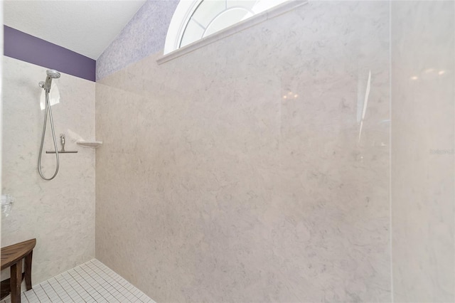 bathroom featuring tile patterned flooring and a tile shower