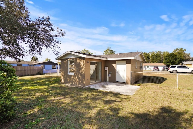 rear view of house with a yard and a patio