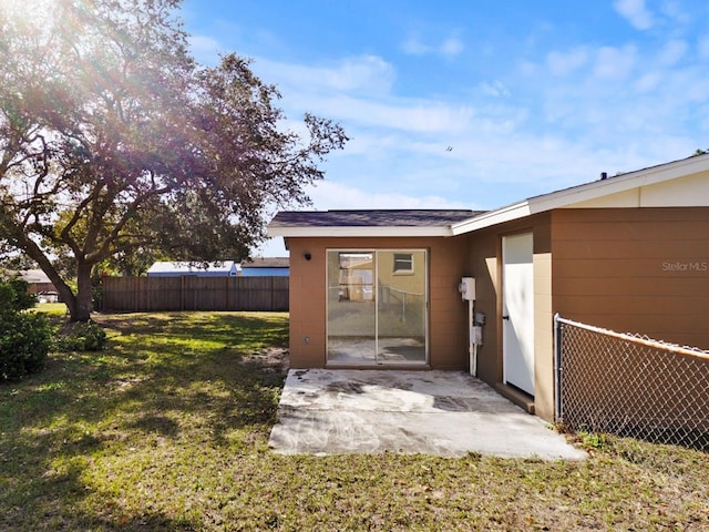 back of property with a patio area and a yard