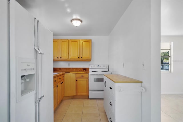 kitchen featuring wood counters, light tile patterned flooring, white appliances, and light brown cabinets