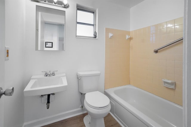 full bathroom with hardwood / wood-style flooring, sink, tiled shower / bath, and toilet