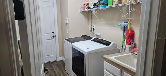 laundry area with dark wood-type flooring, separate washer and dryer, and sink