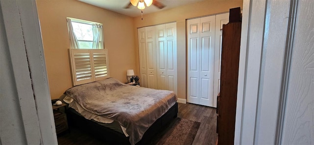 bedroom with ceiling fan, multiple closets, and dark hardwood / wood-style flooring