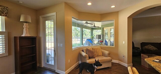 living area with baseboards, recessed lighting, arched walkways, dark wood-style floors, and a ceiling fan