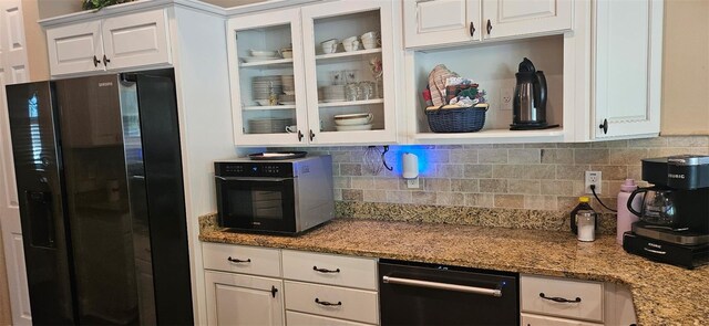 kitchen with black appliances, white cabinets, glass insert cabinets, and tasteful backsplash